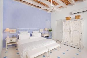 a white bedroom with blue walls and a bed and two tables at Hotel Casa Quero in Cartagena de Indias +86 photos