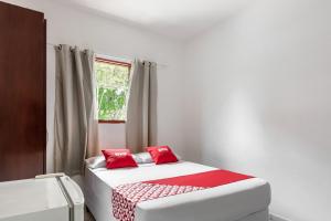 a bedroom with two beds with red pillows at OYO Pousada Tia Léo Campinas in Campinas