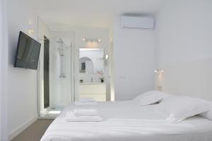 a white bedroom with a bed and a tv at Canary Lofts Palace in Santa Cruz de Tenerife