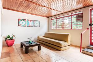 a living room with a couch and a table at OYO Pousada Tia Léo Campinas in Campinas