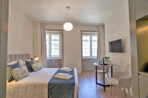ポルトにあるClérigos Prime Suites by Porto City Hostsのベッドルーム1室(ベッド1台、テーブル、椅子付)