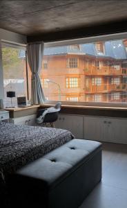 1 dormitorio con cama y ventana grande en Edificio UMAIN en San Martín de los Andes
