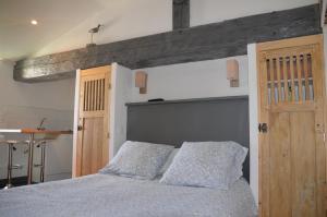 a bedroom with a large bed with a wooden headboard at Le Mole (Appartements et Chambres) in La Flotte