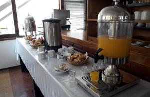 una mesa con una licuadora con una jarra de zumo de naranja en Hotel Tiburones Club en Villa Gesell