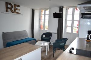 a small living room with a couch and chairs at Le Mole (Appartements et Chambres) in La Flotte