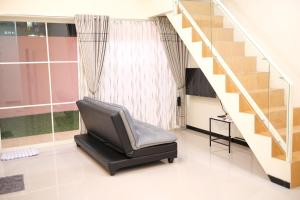 einen schwarzen Stuhl in einem Zimmer mit einer Treppe in der Unterkunft Villa Dean in Batu