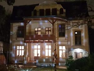 ein großes weißes Haus in der Nacht mit Lichtern in der Unterkunft Residenz Villa Kult in Berlin