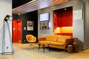 a waiting room with a couch and a chair at Ibis Styles Paris Massena Olympiades in Paris