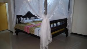 a bedroom with a bed with a canopy at Samudra Guest House in Mirissa
