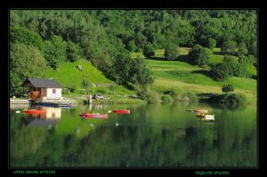a group of boats on a lake with a house at Hostal Casa Rosita in Eriste