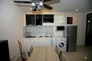 a kitchen with a sink and a refrigerator at Wongamat Privacy Naklua Soi 16-2 in North Pattaya
