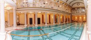 a large swimming pool in a building with columns at Londonskaya SPA Hotel in Odesa