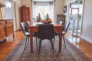 a dining room table with chairs and a bowl of fruit on it at One Above in Cape Town