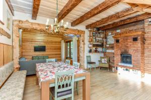 a dining room with a table and a fireplace at Sodyba Latkrantė, Druskininkai in Latežeris