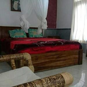 - une chambre avec un lit et une couverture rouge dans l'établissement Bali Livin,tayehomestay, à Banjarangkan