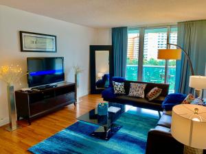 Ocean Reserve by Miami TCS في ميامي بيتش: غرفة معيشة مع أريكة وتلفزيون بشاشة مسطحة