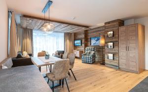 uma sala de estar com uma mesa e cadeiras num quarto em Winklers Gipfelblick Chalet, inklusive Alpentherme - Ganzjährig, Gasteiner Bergbahn - nur Sommer em Bad Hofgastein