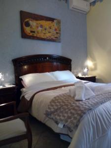een slaapkamer met een bed met een houten hoofdeinde bij VILLETTA SCALA DEI TURCHI a SOLI 40 MT DAL MARE in Realmonte