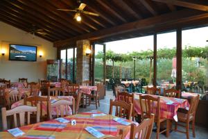 ein Restaurant mit Tischen und Stühlen und einem großen Fenster in der Unterkunft La Grolla Apartments in Manerba del Garda