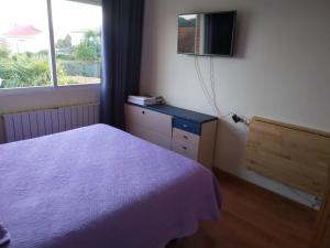 - une chambre avec un lit et une télévision murale dans l'établissement Residencial Playa Lisa, à Boadilla del Monte