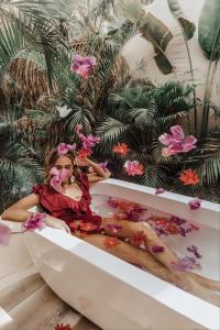 a woman sitting in a bath tub with flowers at Nosara Satori Bubbles in Nosara