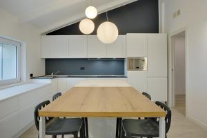 ペスキエーラ・デル・ガルダにあるHomingarda - fine holiday apartmentsの木製のテーブルと椅子のあるキッチン