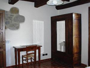 アルチドッソにあるAgriturismo Pian Peruginoの木製テーブル、テーブル、椅子が備わる客室です。
