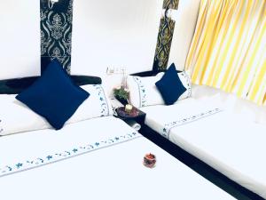 Ashoka Hostel في هونغ كونغ: سريرين في غرفة مع وسائد زرقاء وبيضاء