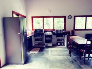 uma cozinha com um frigorífico e uma mesa em Casa da Praia do Félix em Ubatuba