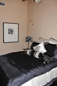 a bedroom with a bed with black sheets and pillows at Frankston Home with Deck and Fishing on Lake Palestine in Coffee City +25 photos
