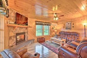 a living room with leather furniture and a fireplace at Rustic Benezette Cabin with Porch, Hot Tub and Fire Pit in Benezette