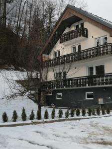 uma casa com uma varanda ao lado dela na neve em Kasita Bled Apartments em Bled