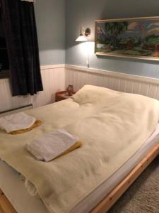 Una cama con sábanas blancas y toallas. en Kong Hans gt. 28, en Andenes