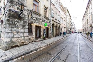 an empty street in an old city with buildings at Apartment Ruska 12 in Lviv