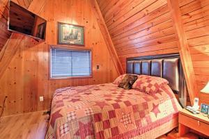 a bedroom with a bed in a wooden cabin at A-Frame Gatlinburg Cabin with Deck and Private Hot Tub in Gatlinburg