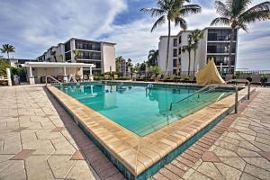 a swimming pool in a resort with palm trees and buildings at Sanibel Island Studio with Pool Access Walk to Beach in Sanibel