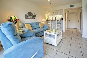 a living room with a blue couch and a table at Sanibel Island Studio with Pool Access Walk to Beach in Sanibel