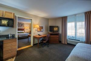 a room with a bed, desk, chair and a television at Candlewood Suites Windsor Locks, an IHG Hotel in Windsor Locks