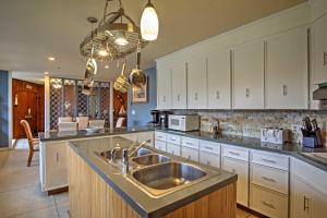 a kitchen with a stainless steel sink and white cabinets at Spacious South Haven Home about 1 Mi to Lake Michigan! in South Haven