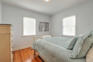 a white bedroom with a bed and two windows at Williams Bay Retreat Walk to Lake Geneva and Town! in Lake Geneva