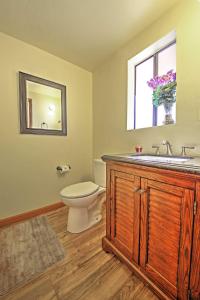 a bathroom with a toilet and a sink and a window at Big Bear Cabin with Fenced Yard 4 Mi to Snow Summit in Big Bear City +16 photos