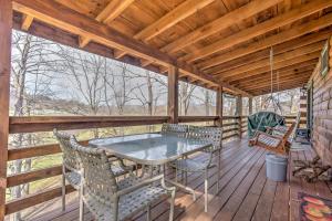 une terrasse en bois avec une table et des chaises. dans l'établissement Serene Cabin in the Smokies with 2 Decks and Hot Tub!, à Waynesville