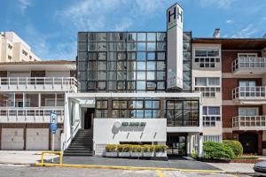 aartment building with a building with a sign in front of it at Hotel Club del Golf in Mar del Plata