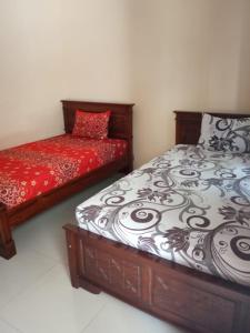 una camera con due letti con lenzuola rosse e bianche di Hotel Surya Utama - Syariah a Probolinggo