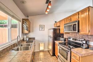 uma cozinha com utensílios de aço inoxidável e armários de madeira em East Tucson House with Private Backyard and Fire Pit em Tucson