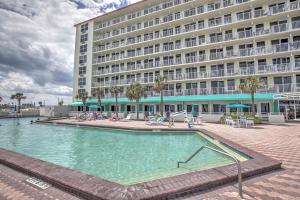 um grande hotel com uma grande piscina em frente a um edifício em Daytona Beach Resort Condo 1 Mi to Ocean Center! em Daytona Beach