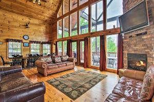 a living room with leather furniture and a fireplace at Expansive Gatlinburg Cabin Hot Tub, Deck and Grill! in Gatlinburg