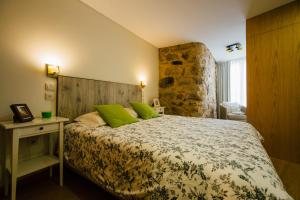 a bedroom with a large bed with green pillows at Vougaldeias Casas da Seara in Sever do Vouga +82 photos