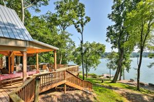 a house with a large deck next to the water at Lakefront Rutledge Home with Fire Pit and Private Dock in Rutledge