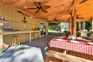 a porch with a table and a ceiling fan at Lakefront Rutledge Home with Fire Pit and Private Dock in Rutledge